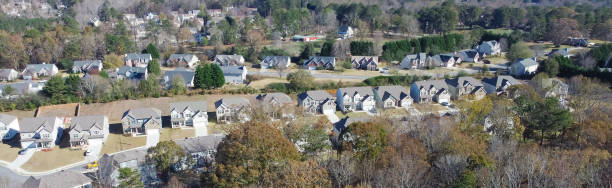 Panorama suburban subdivision sprawl with row of high density brand new two story houses along park autumn leaves outside Atlanta, Georgia, USA stock photo