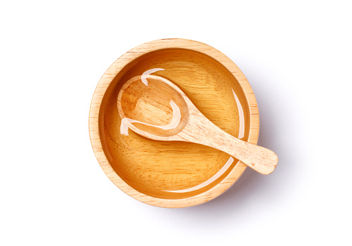 Sugar syrup in wooden bowl isolated on white background with clipping path. Top view, flat lay.