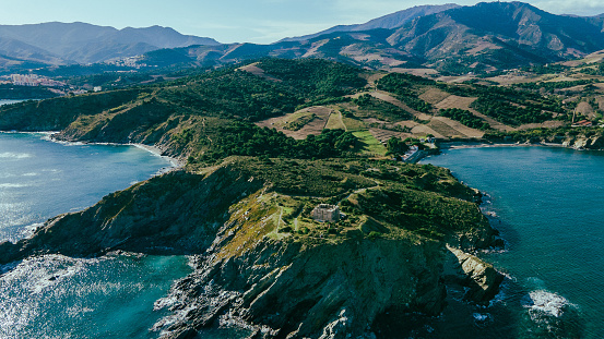 Drone shot of the Pyrenees from the sea, sunny day, end of the chain of mountain in the sea, catalan mountains, Mavic Air 2