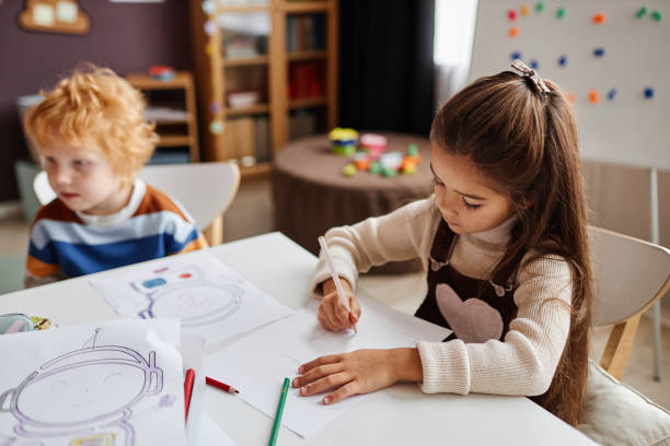 istock Little learner of nursery school drawing picture on paper 1443547883