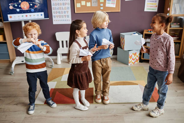 istock Several intercultural kids in casualwear playing paper planes 1443548719