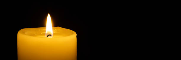 istock a burning candle on the black backgrounds 1443549150