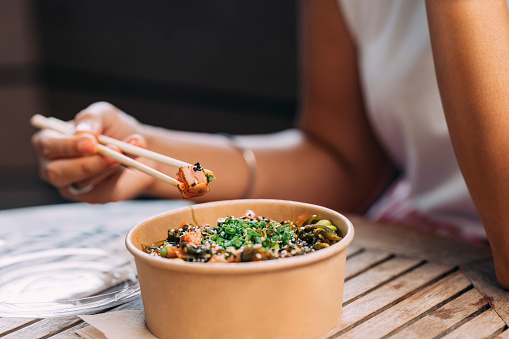 A cropped photo of an unrecognizable Asian female having a healthy meal.