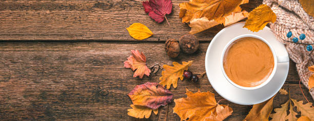 istock Coffee mug, sweater and foliage on a wooden background. Top view, copy space. 1443552852