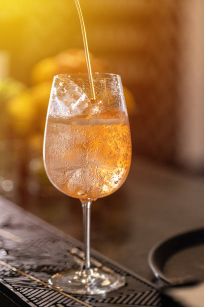 Long fizzy drink concept Bartender pouring prosecco in wine glass with ice cube. Long fizzy drink. club soda stock pictures, royalty-free photos & images