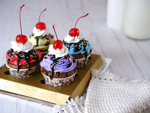Colourfull cupcakes in a table and white background