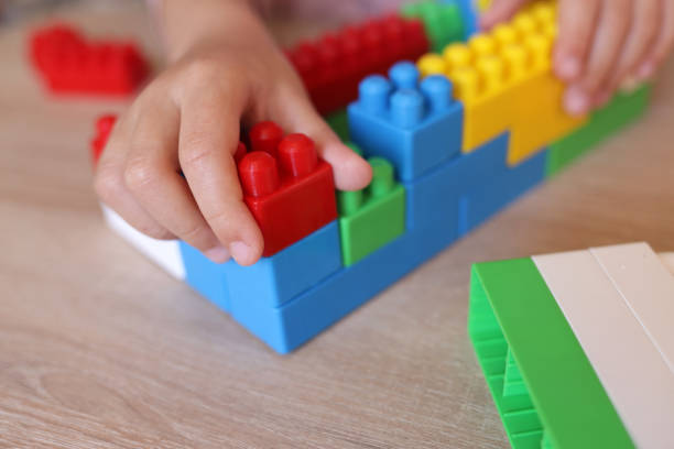 istock child builds a house from a constructor of colored bricks, hands close-up 1443555074