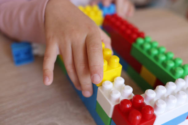 istock child plays with a designer on the table, builds walls from blocks 1443555077