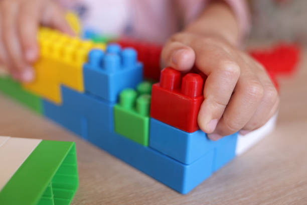 istock child builds a house from a constructor of colored bricks, hands close-up 1443555099