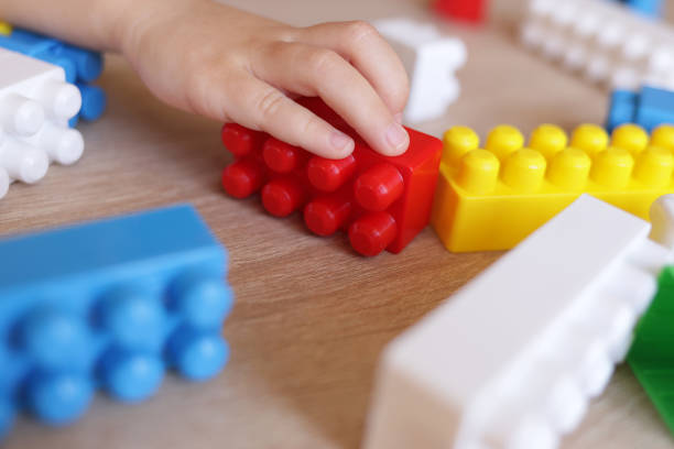 istock child builds a house from a constructor of colored bricks, hands close-up 1443555107