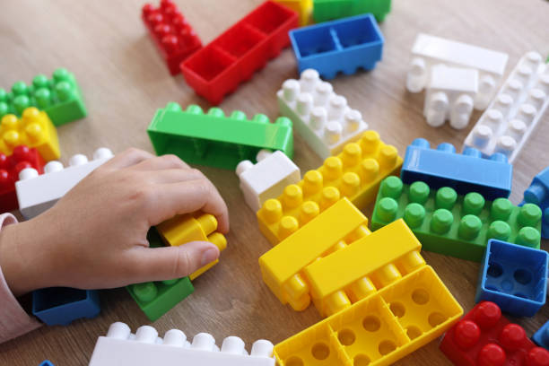 istock child plays with a designer on the table, builds walls from blocks 1443555623