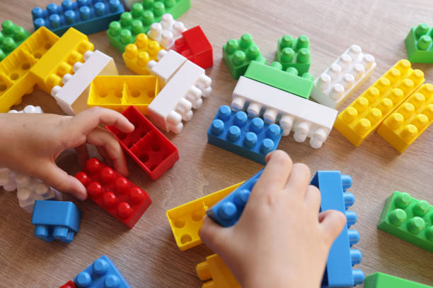 istock child plays with a designer on the table, builds walls from blocks 1443555641
