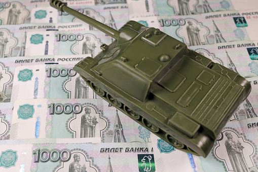 toy tank on the russian banknotes roubles, war conflict russia ukraine, Sanctions, crisis concept