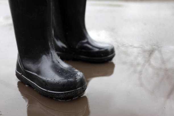 istock child in rubber boots in a puddle after rain 1443557560