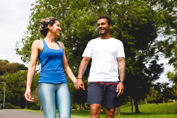 istock a man and a woman walk hand in hand outdoors while talking 1443559012