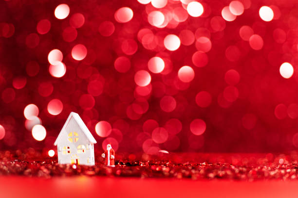 Little houses ornaments hanged on a Christmas light rope. the window of the houses is shaped like a star