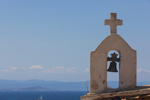 cross and bell of a chapel in the upper town of Bonifacio on the French island of Corsica; Bonifacio, France