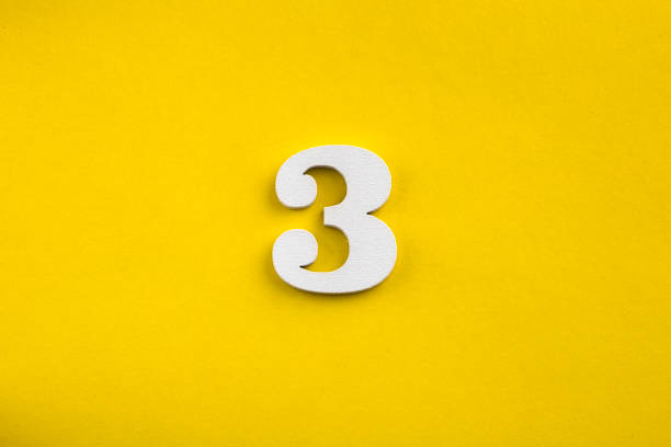 istock number three - white number in wood on yellow background 1443563808