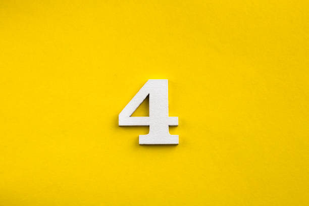 istock Number 4 - White wooden number on yellow background 1443563809