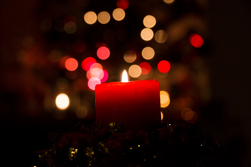 Candle and Christmas lights on the table.