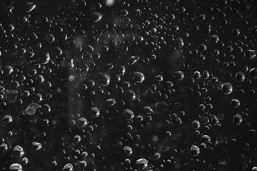 Drops of water on glass on a black background.