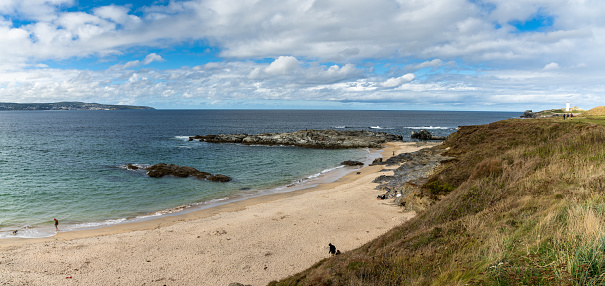 view of St. Ives Bay in Cornwall and small beach near Gwithian with the Godrevy Lighthouse in the background
