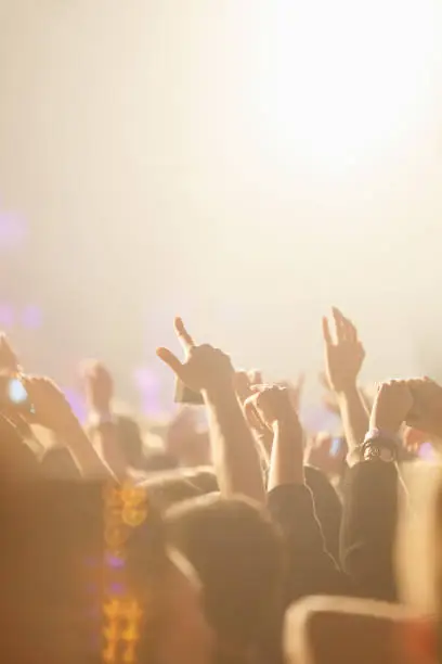 Photo of Bright concert background with happy music fans put hands up to favorite musician set
