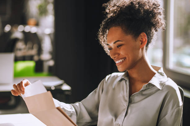 istock Joyous businesswoman looking at documentation in her hand 1443570292