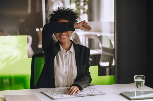 istock Visually impaired woman seated at the office table using Braille 1443570892
