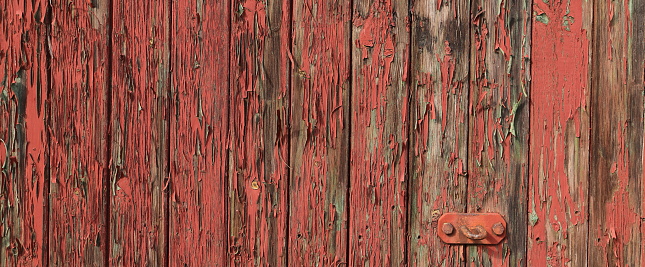 an old wooden wall with red peeling paint