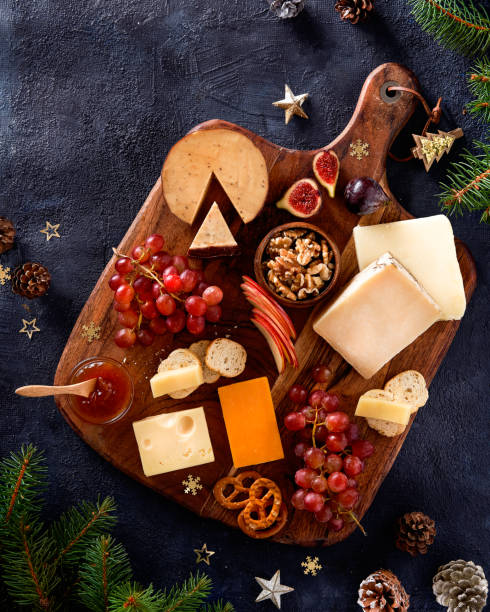 istock Christmas cheese platter with grapes, nuts, figs on a dark background. Top view. Xmas gourmet holiday appetizer. 1443572210