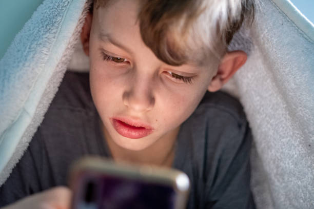 istock the boy is looking at the phone 1443573094