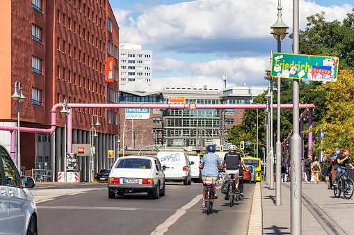 Berlin, Germany - A view of road and pavement users on a sunny day in the Friedrichshain district of Berlin, alongside the Spree river.