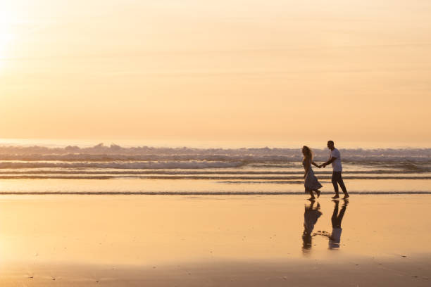 istock Fond couple walking on beach at sunset 1443575640
