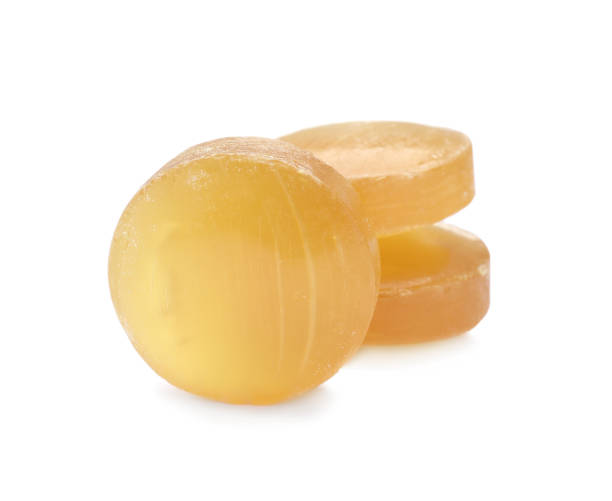 gouttes de toux jaune sur fond blanc. produit pharmaceutique - cough lozenge photos et images de collection