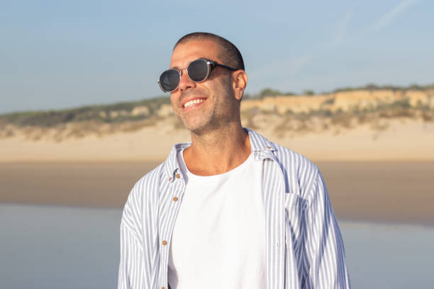 istock Portrait of attractive young man on beach 1443576352