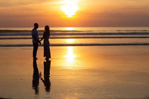 istock Tender family walking on beach at sundown 1443576483