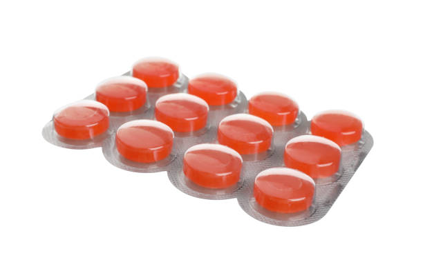 Blister with orange cough drops isolated on white