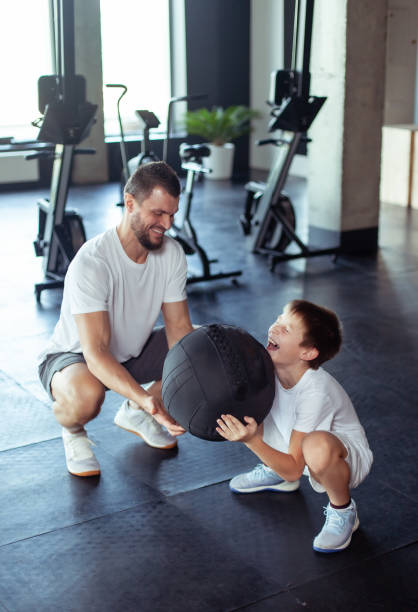 Teenager trains with a personal trainer in the gym. Children's fitness stock photo