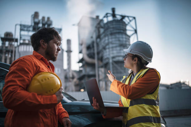istock Two engineers using laptop, working late night at refinery plant. 1443576912