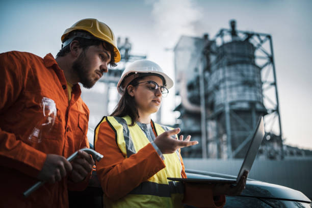 istock Two engineers using laptop, working late night at refinery plant. 1443576933