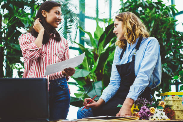 istock Two young women discuss project in workplace 1443576982