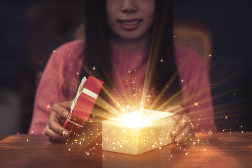 Young woman opening gift box with smiling face