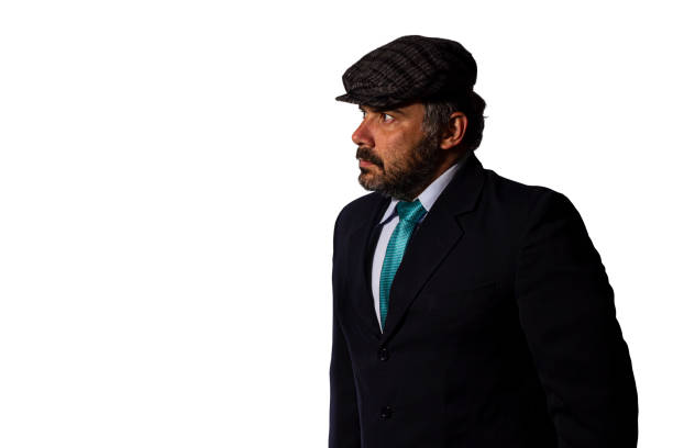Businessman looking aside wearing a suit and a flat cap.