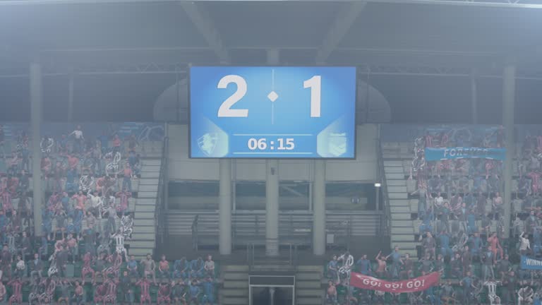 Football Soccer Stadium Championship Match, Zoom In on Scoreboard Screen Showing Score of 2:1. Crowd of Fans Cheering, Screaming, Having Fun. Sport Channel Television Advertising Playback Concept