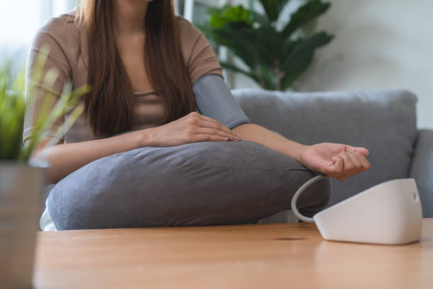 istock Young women check blood pressure at home 1443587675