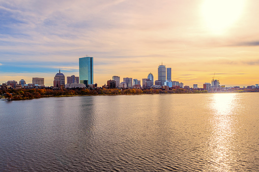 Panoramic view across the Charles River of an autumn sunset and the Boston skyline.