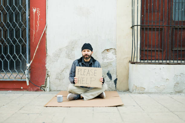 istock Poor homeless beggar feeling hungry holding a sign 1443592487