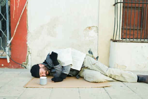 istock Poor miserable homeless man sleeping looking cold and hungry 1443593394