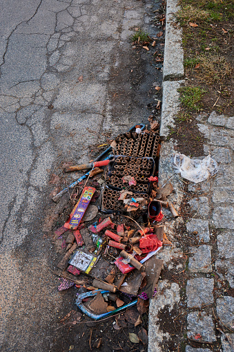 Berlin, Germany - January 1, 2022: Various remains of a New Year's Eve celebration on the sidewalk of a street.